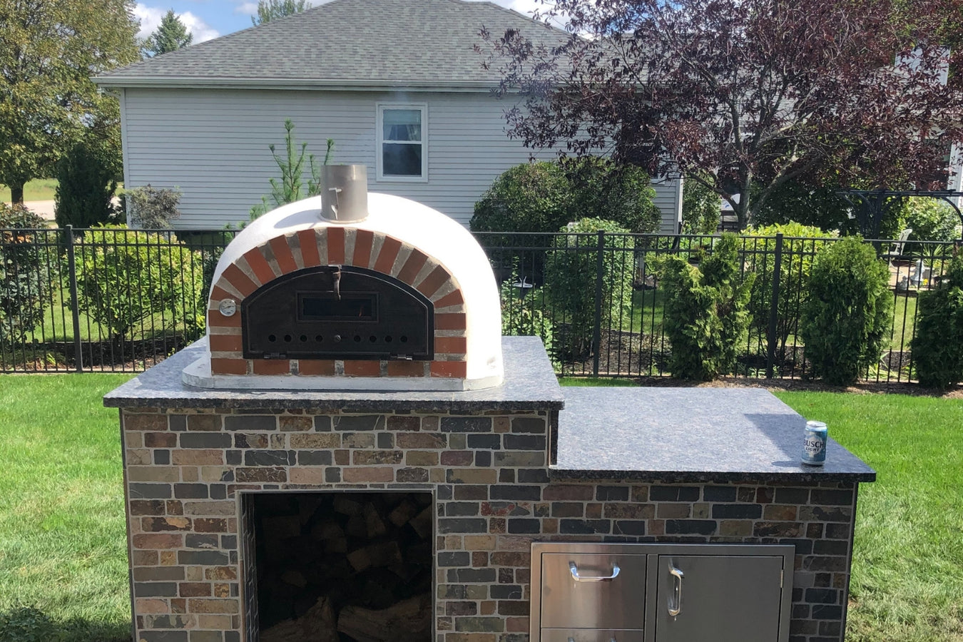 authentic pizza oven which is from the traditional range with brick bench and log storage underneat in back yard
